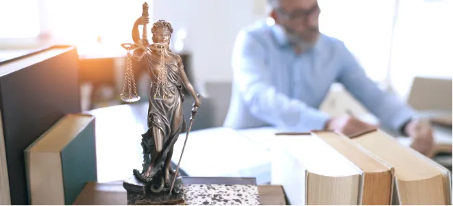 Statue der Gerechtigkeit auf dem Schreibtisch eines Anwalts